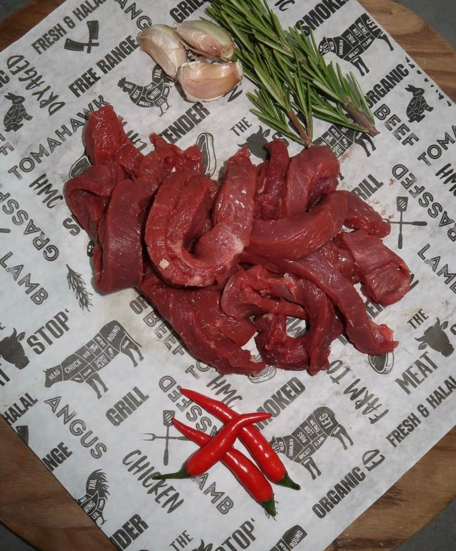 Raw meat slices with red chili peppers and rosemary on The Meat Stop branded paper background